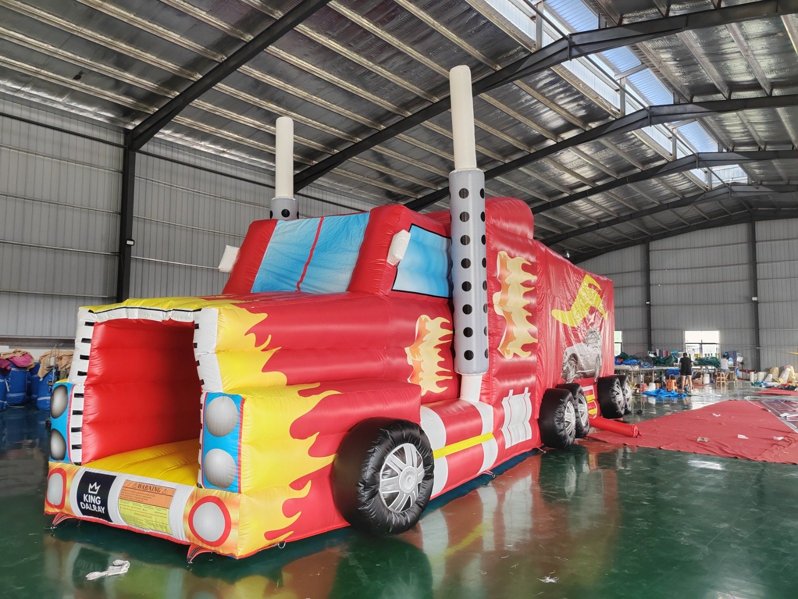 Red fire-engine-themed inflatable castle with a slide